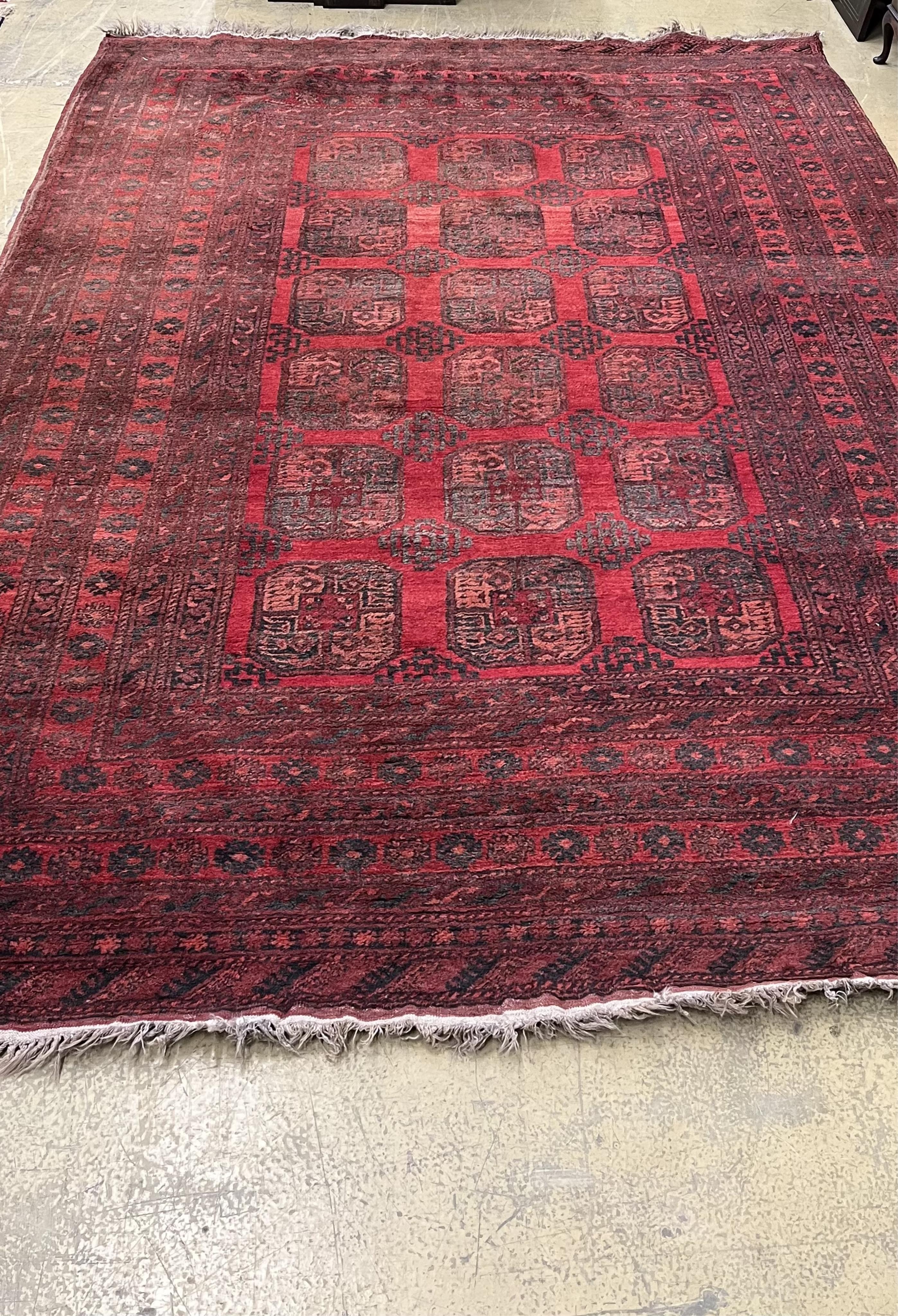 An Afghan red ground carpet, 330 x 240cm. Condition - fair